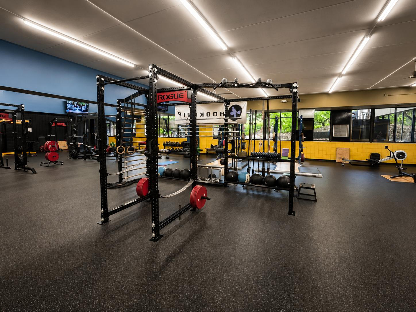 Olympic lifting cage with barbells, bumper plates, and safety equipment at Cleveland Fitness Club